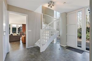 a white spiral staircase in a living room at Villa Mastlo 2x 10 persons Ouddorp large garden, 1500 meters to the dunes and beach with 2 jacuzzi's - not for companies in Ouddorp