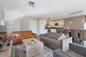 a living room with a couch and a table at Villa Mastlo 2x 10 persons Ouddorp large garden, 1500 meters to the dunes and beach with 2 jacuzzi's - not for companies in Ouddorp