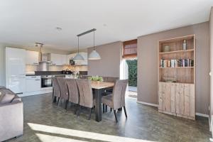 a kitchen and dining room with a table and chairs at Villa Mastlo 2x 10 persons Ouddorp large garden, 1500 meters to the dunes and beach with 2 jacuzzi's - not for companies in Ouddorp +127 photos