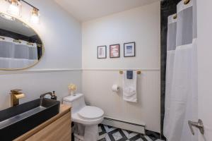 a bathroom with a sink and a toilet and a mirror at Stylish 2 BD Apt-18 mins from NYC-Steps away Bus stop, Restaurants, Groceries in Jersey City +33 photos