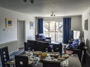 a living room with couches and a table and chairs at Apartment 15 Harvest Moon in Newquay +14 photos