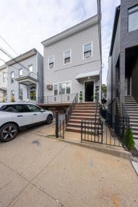 a white car parked in front of a house at Stylish 2 BD Apt-18 mins from NYC-Steps away Bus stop, Restaurants, Groceries in Jersey City