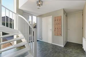 een witte trap in een kamer met een deur bij Villa Mastlo 2x 10 persons Ouddorp large garden, 1500 meters to the dunes and beach with 2 jacuzzi's - not for companies in Ouddorp