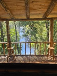 two chairs on a porch with a view of a lake at Cabaña Refugio Cascada in Llanada Grande