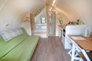 a small room with a green couch in a tiny house at Langley Dam Glamping in Langley