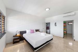 ein Schlafzimmer mit einem großen weißen Bett mit rosa Kissen in der Unterkunft Villa Barbulete - Exclusive luxury sea view villa at Cas Abou in Dorp Soto