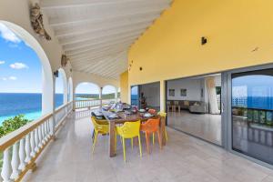 ein Esszimmer mit Tisch und Stühlen auf einem Balkon in der Unterkunft Villa Barbulete - Exclusive luxury sea view villa at Cas Abou in Dorp Soto