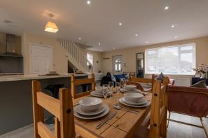 ブロックワースにあるpet friendly house by KBS StayHub Short Lets & Serviced Accommodation Brockworth with parkingのダイニングルーム、リビングルーム(木製テーブル付)