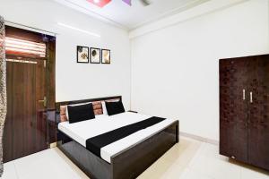 a bedroom with a bed and a wooden door at Hotel O Parth Hotel And Restaurant in Fīrozābād