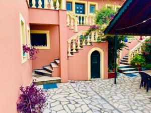 a pink building with stairs and a door at Makris Apartments in Roda