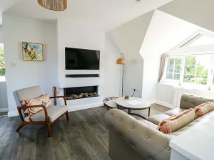 un salon avec un canapé et une cheminée dans l'établissement The Gatekeepers Cottage - Skerry Vore, à Llandudno Junction