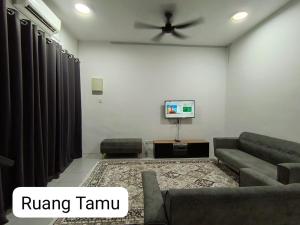 a living room with a couch and a ceiling fan at Homestay AinulZahra- For Malays Only in Seri Iskandar