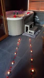 a hot tub with a table and two glasses of wine at Maison Soleya Brussels, private spa and love room in Asse +5 photos