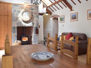 a living room with a table and a fireplace at The Byre in Saint Twynnells