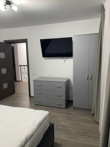 a bedroom with a dresser and a tv on a wall at Vila Cantacuzino in Buşteni