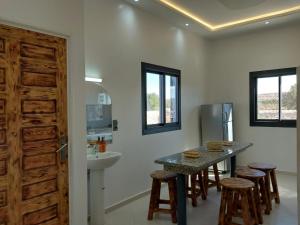 a kitchen with a sink and a table with stools at Villa chaima in Essaouira