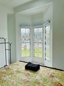 a bedroom with a bed and two windows at Lake House Sepang88 in Sepang