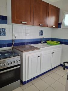a kitchen with white cabinets and a stove at Résidence Nesrine Yasmine Hamammet in Yasmine