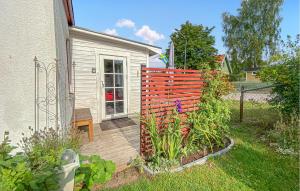 a backyard with a fence and a wooden deck at Lovely Apartment In Borgholm With Wifi in Borgholm