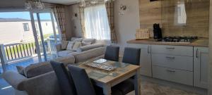 Una cocina y una sala de estar con mesa y sillas. en Platinum villa, en Whitstable 3 fotos más