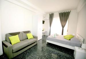 a bedroom with a couch and a bed with yellow pillows at B&B Salernoway in Salerno