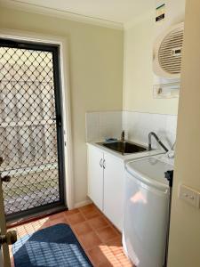 Una pequeña cocina con fregadero y ventana. en Casablanca Beach House, en Torquay 33 fotos más