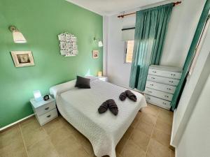 Un dormitorio con una cama con dos pantuflas encima. en Casa Ñaña Pay, en La Mareta 12 fotos más