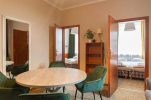 a room with a table and chairs and a bedroom at Inza Guest House in Druskininkai