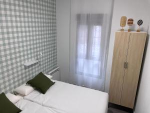 ビルバオにあるConfortable apartamento con parking en Bilbaoの白いベッドと窓のある小さな寝室