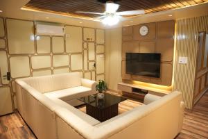 a living room with a couch and a tv at Hotel Laxmi Premium in Jāmb +9 photos