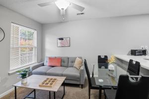 una sala de estar con un sofá y una mesa en Near Fort Liberty Modern 1br I Free Parking I Gym, en Spring Lake