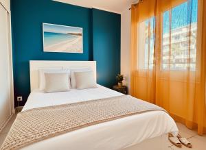 a bedroom with a bed with a blue wall at Superbe T2 vue mer avec ascenseur 22 in Canet-en-Roussillon