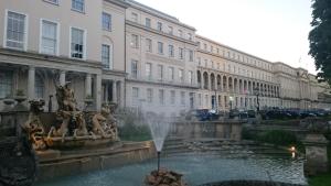 a fountain in front of a building with a building at Rooms on The Prom in Cheltenham