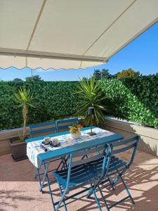 a blue table and chairs under an umbrella on a patio at Stella Maris - Private Apartment in Bari