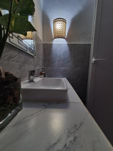 a bathroom with a sink and a pendant light at Faraja Homestay Mwanza in Mwanza