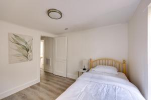 a white bedroom with a bed with a wooden headboard at Birmingham Area Retreat 2 Mi to Dtwn Bessemer in Bessemer