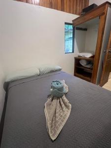 Un dormitorio con una cama con un animal de peluche encima. en Peaceful Jungle Home, River Access, Arenal Views, en El Castillo de La Fortuna