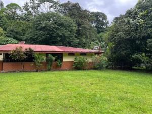 una casa con un patio de hierba delante de ella en Peaceful Jungle Home, River Access, Arenal Views, en El Castillo de La Fortuna