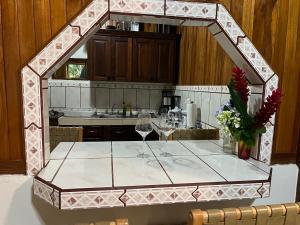 cocina con mesa y 2 copas de vino en Peaceful Jungle Home, River Access, Arenal Views, en El Castillo de La Fortuna