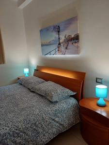 a bedroom with a bed with two blue lamps at Stella Maris - Private Apartment in Bari