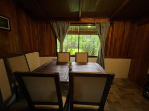 Un comedor con mesa y sillas y una ventana. en Peaceful Jungle Home, River Access, Arenal Views, en El Castillo de La Fortuna 16 fotos más