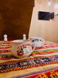 two tea cups sitting on top of a rug at Cabaña El Solcito, con parque y pileta compartida in Chascomús
