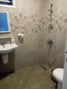 un bagno con doccia, lavandino e WC di Studio moderne avec parking privé et Wi-Fi gratuit a Sfax