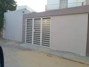 una porta bianca sul lato di una casa di Studio moderne avec parking privé et Wi-Fi gratuit a Sfax