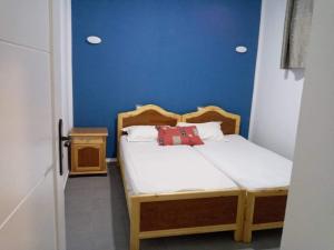 una piccola camera con letto e parete blu di Studio moderne avec parking privé et Wi-Fi gratuit a Sfax