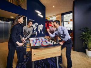 维也纳维也纳市阿德吉奥公寓式酒店的一群人站在一张桌子旁,拿着棋盘