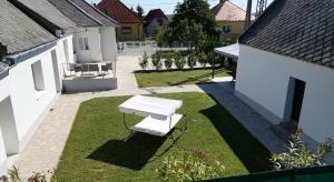 a white bench sitting in the middle of a yard at Varázsvilág Vendégház in Olaszfalu