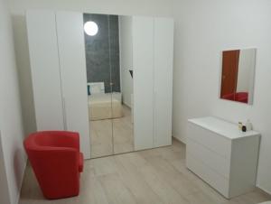 a bathroom with a red chair and a mirror at Casa Letizia in Bernalda