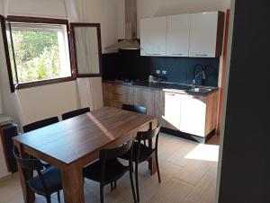 a kitchen with a wooden table and black chairs at Casa Letizia in Bernalda