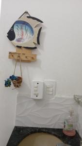 a bathroom with a toilet with a fish on the wall at Charming and comfortable Kitnet in Marataizes +3 photos